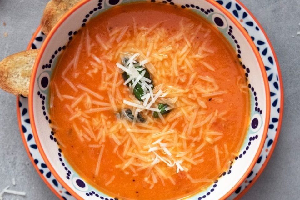 orange soup on white and blue ceramic bowl