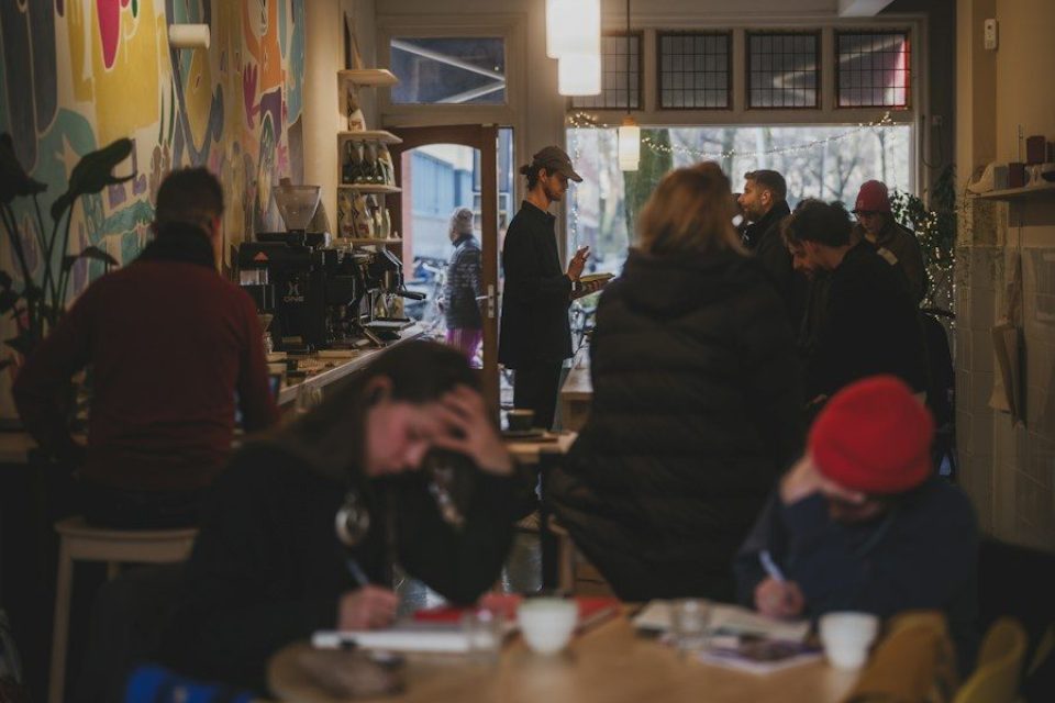 People gathered inside a cafe with colorful wall art